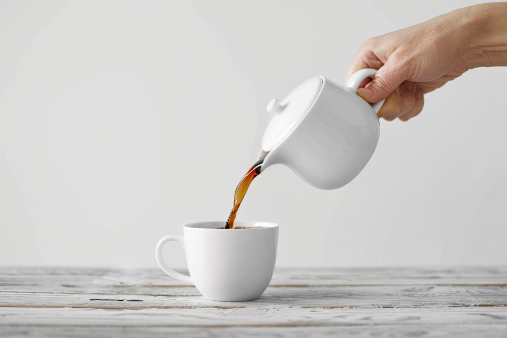 person pouring coffee into coffee cup